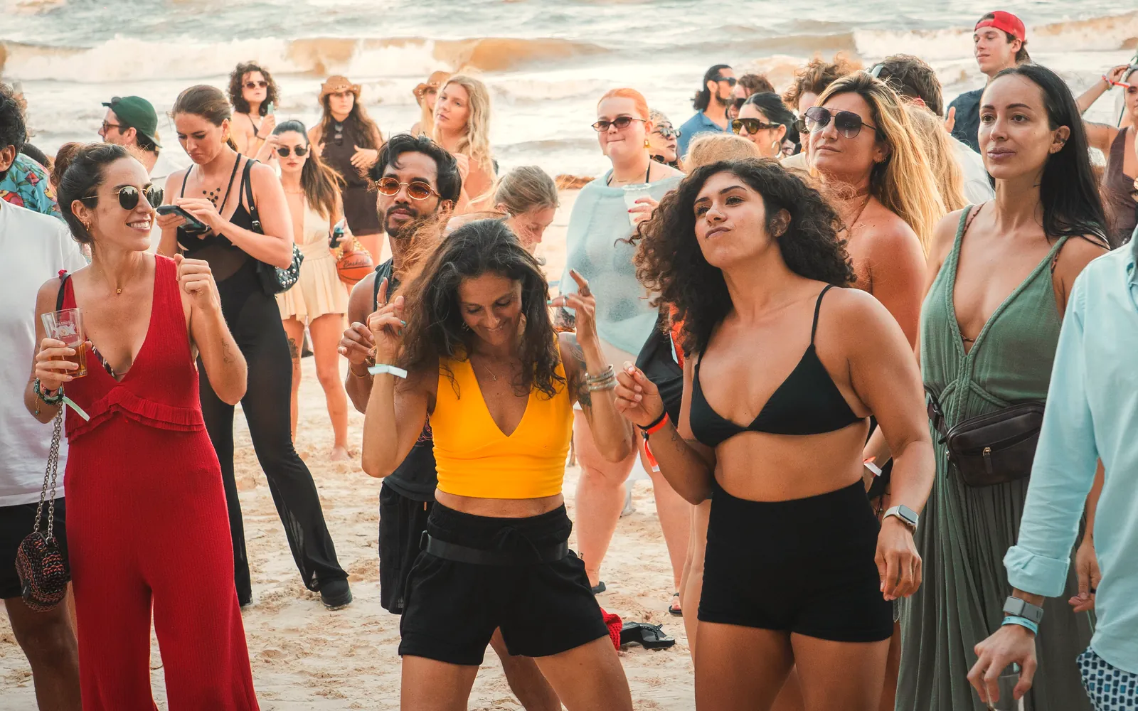 A crowd dancing on the beach in Tulum